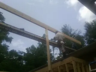 Carpenter setting a ridge beam over a new addition frame — Ice Dam Removal by Roofing Brothers in Brayton