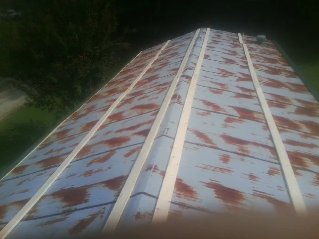 Rusted metal roof panels with new wood purlins before replacement — Storm Damage Roof Repair in Brayton by Roofing Brothers