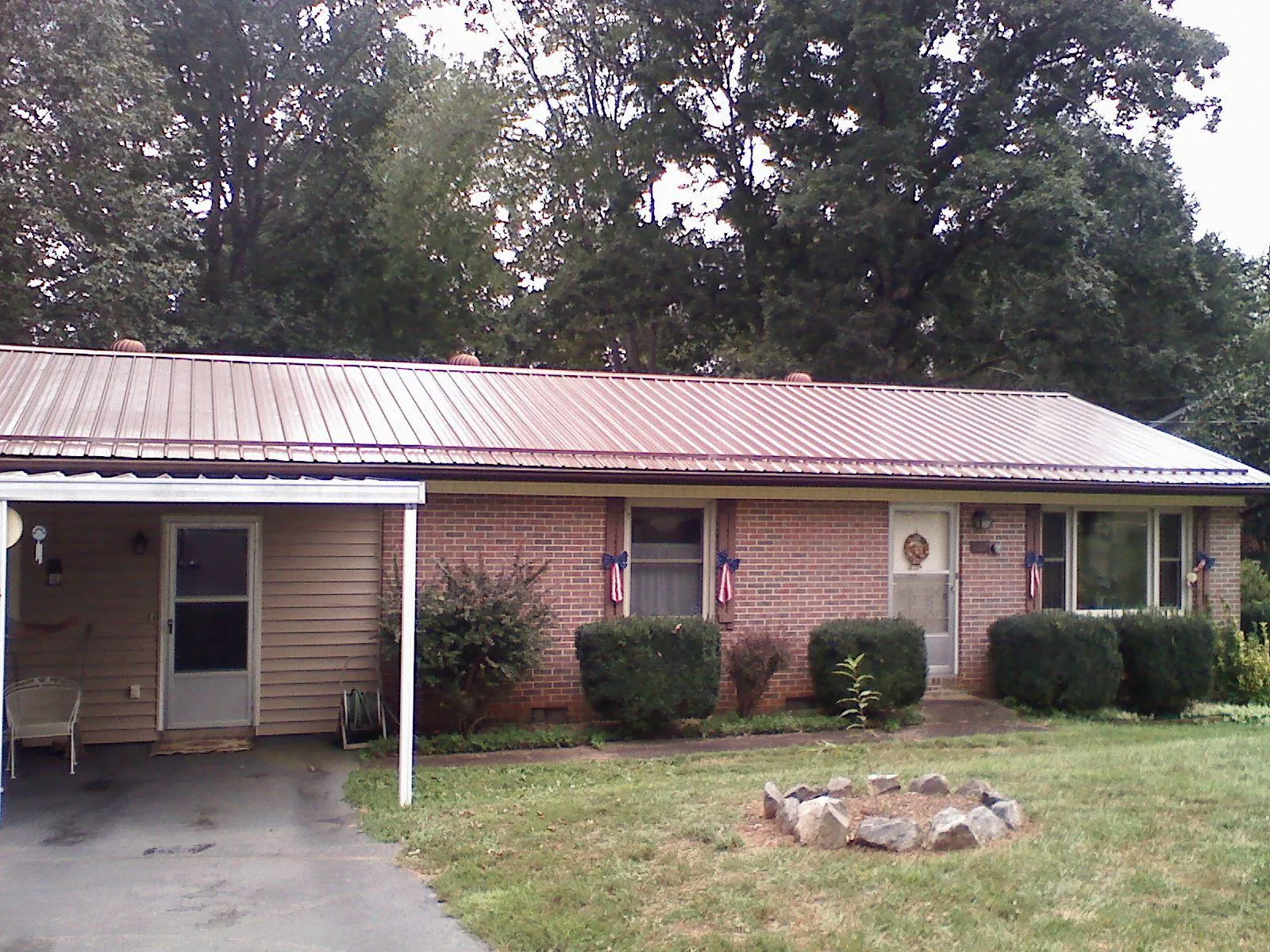 Bronze metal roof and carport on a brick ranch home — Roof Repair work by our crew in Brayton